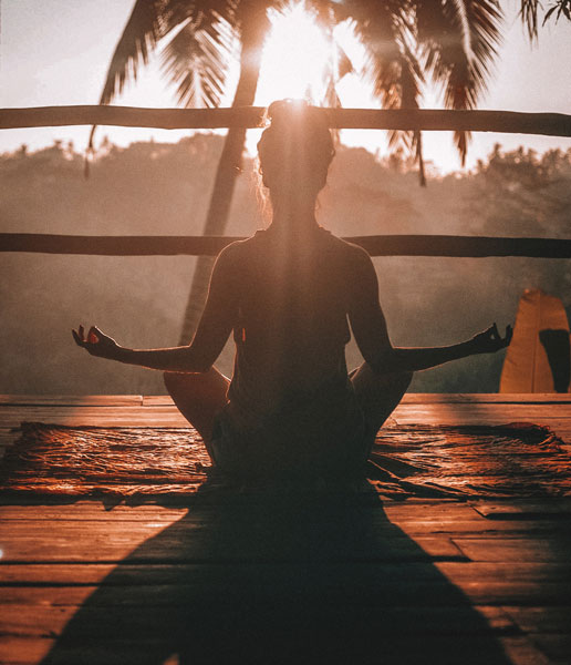 Frau in Meditationshaltung verbindet sich mit Kronenchakra.